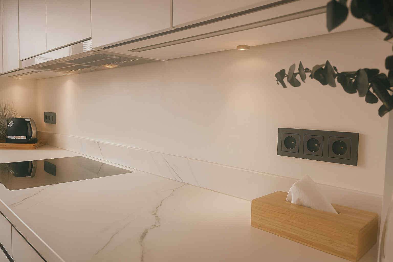 Tumedad mustades toonides pistikupesad valges köögis