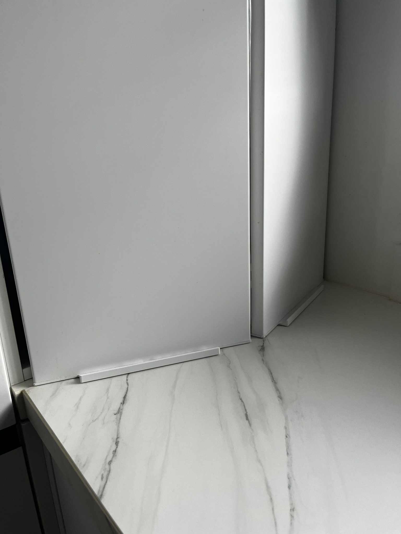 Köögimööbli nurga detailvaade mustade käepidemega